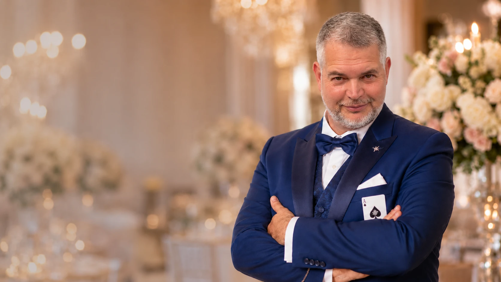 Tom Gryf, svatební kouzelník, v elegantním modrém obleku na svatební hostině